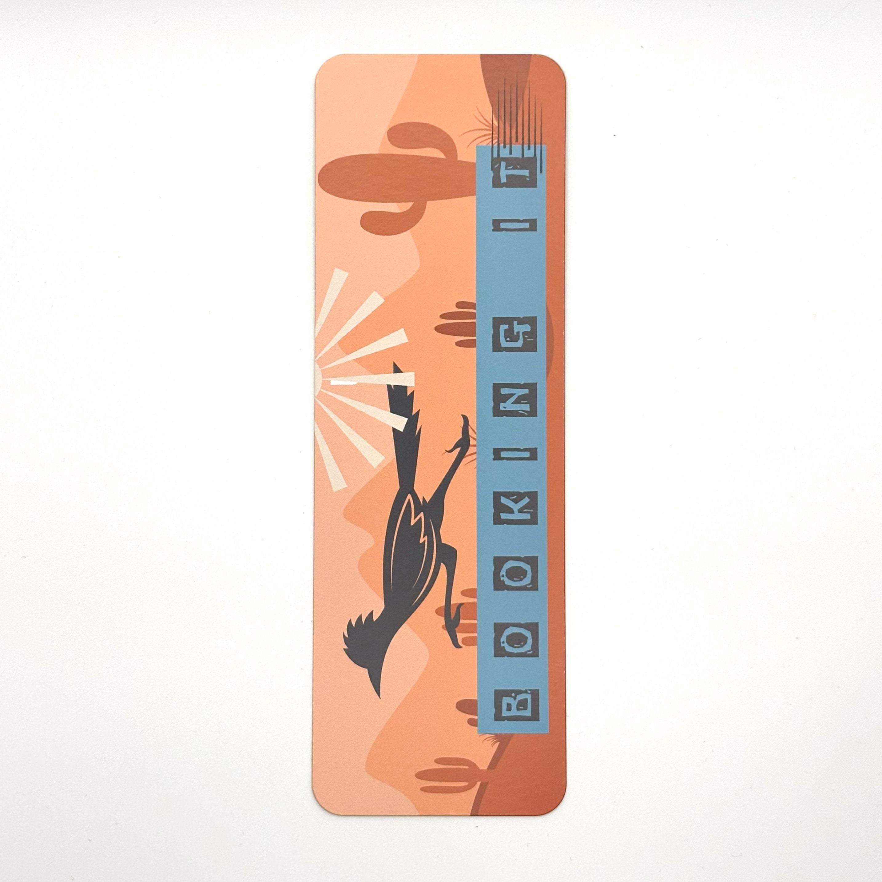 Bookmark with roadrunner cactus landscape and quote "booking it" on an orange background