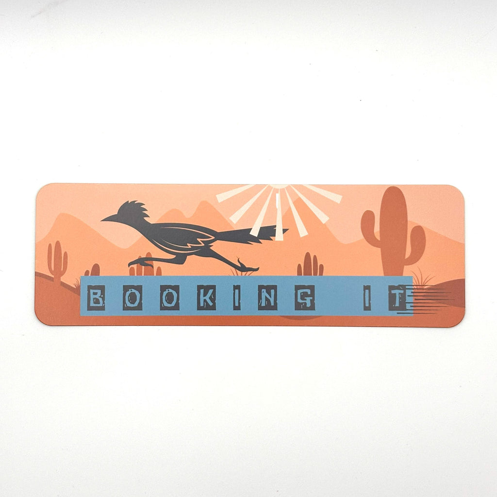 Bookmark with roadrunner cactus landscape and quote "booking it" on an orange background