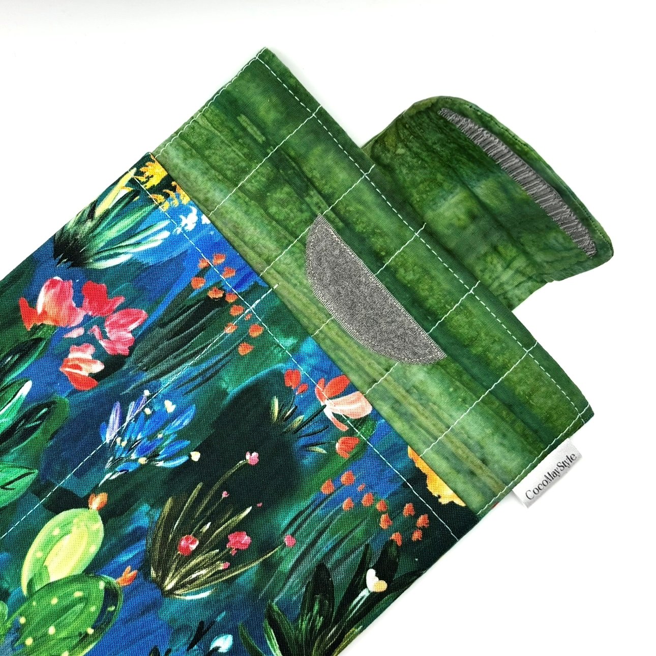 E-Reader sleeve with colorful floral and plant pattern on a blue background showing open velcro flap