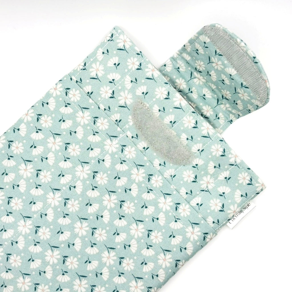 E-Reader sleeve with floral patterned fabric on a light blue background showing open velcro flap