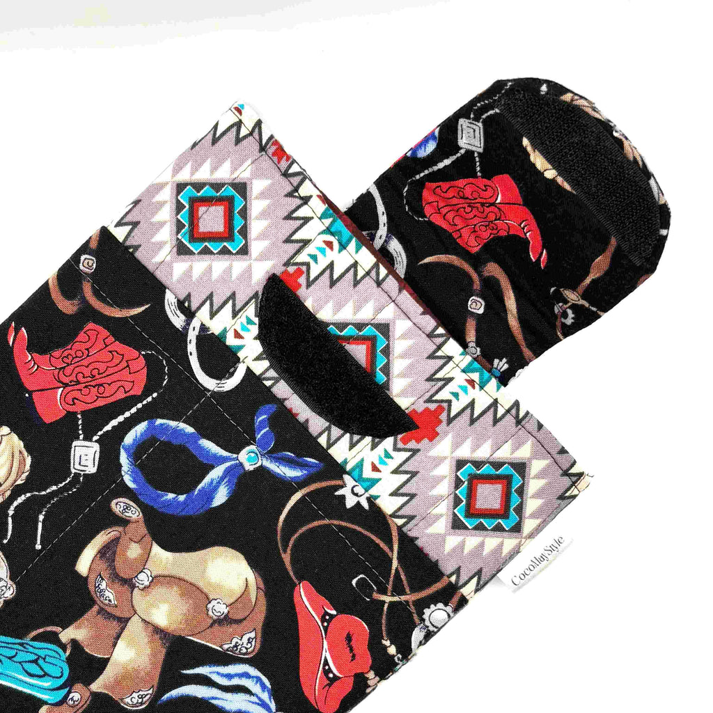 E-Reader sleeve with cowboy-themed design including hats, boots, and ropes showing open velcro flap