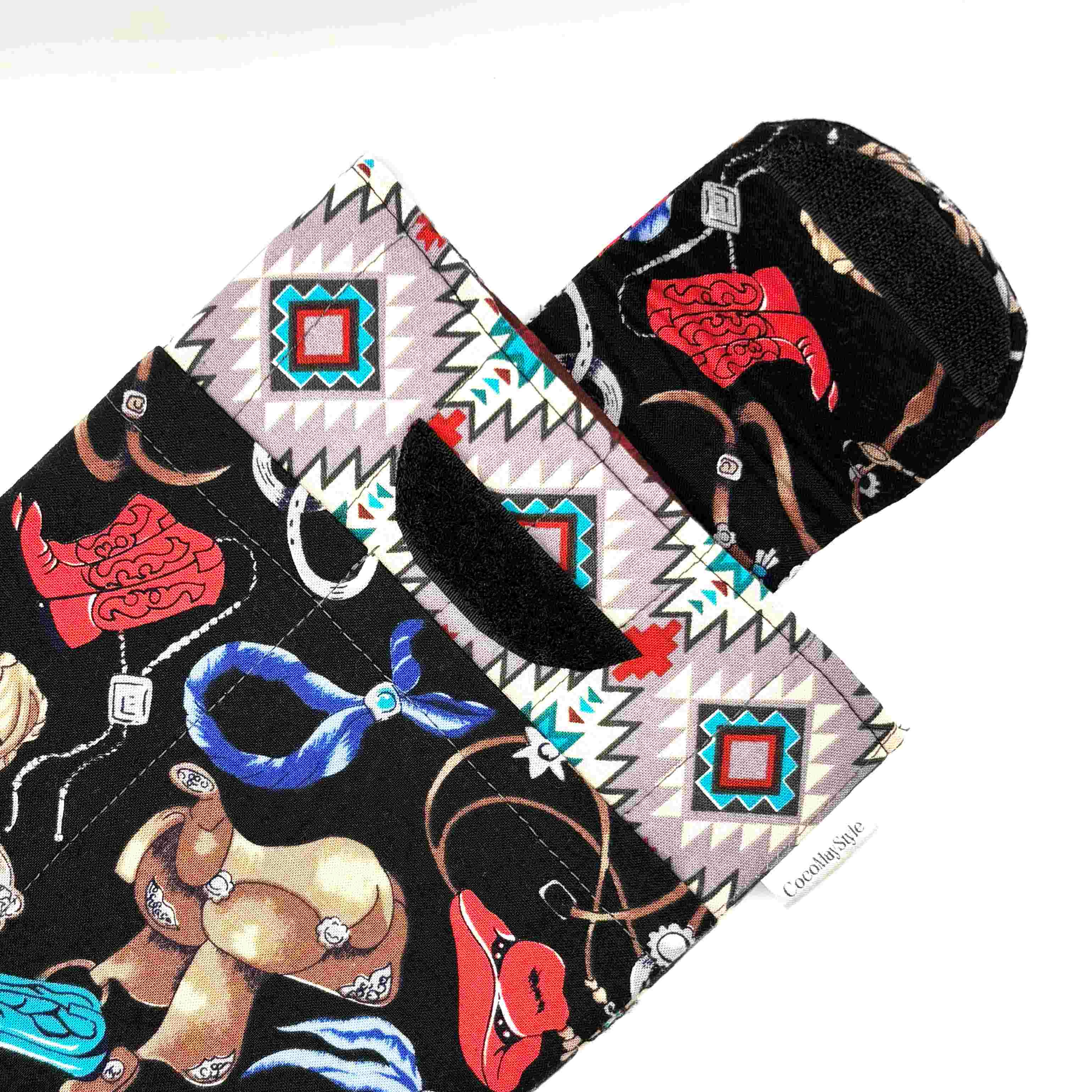 E-Reader sleeve with cowboy-themed design including hats, boots, and ropes showing open velcro flap