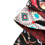 Close-up of e-Reader sleeve with cowboy-themed design including hats, boots, and ropes
