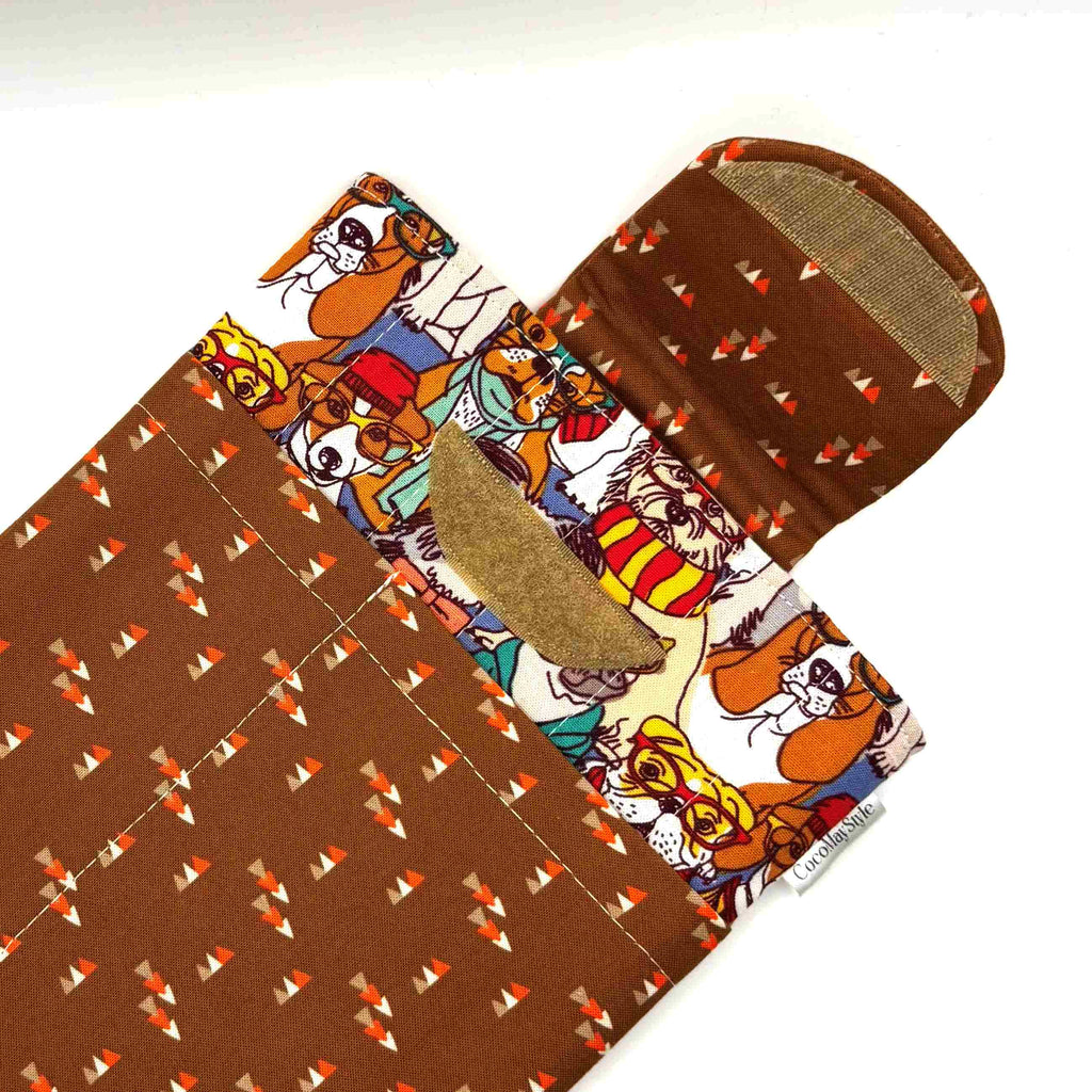 E-Reader sleeve with patterned dogs wearing hats, glasses, and scarves showing open velcro flap