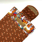 E-Reader sleeve with patterned dogs wearing hats, glasses, and scarves showing open velcro flap