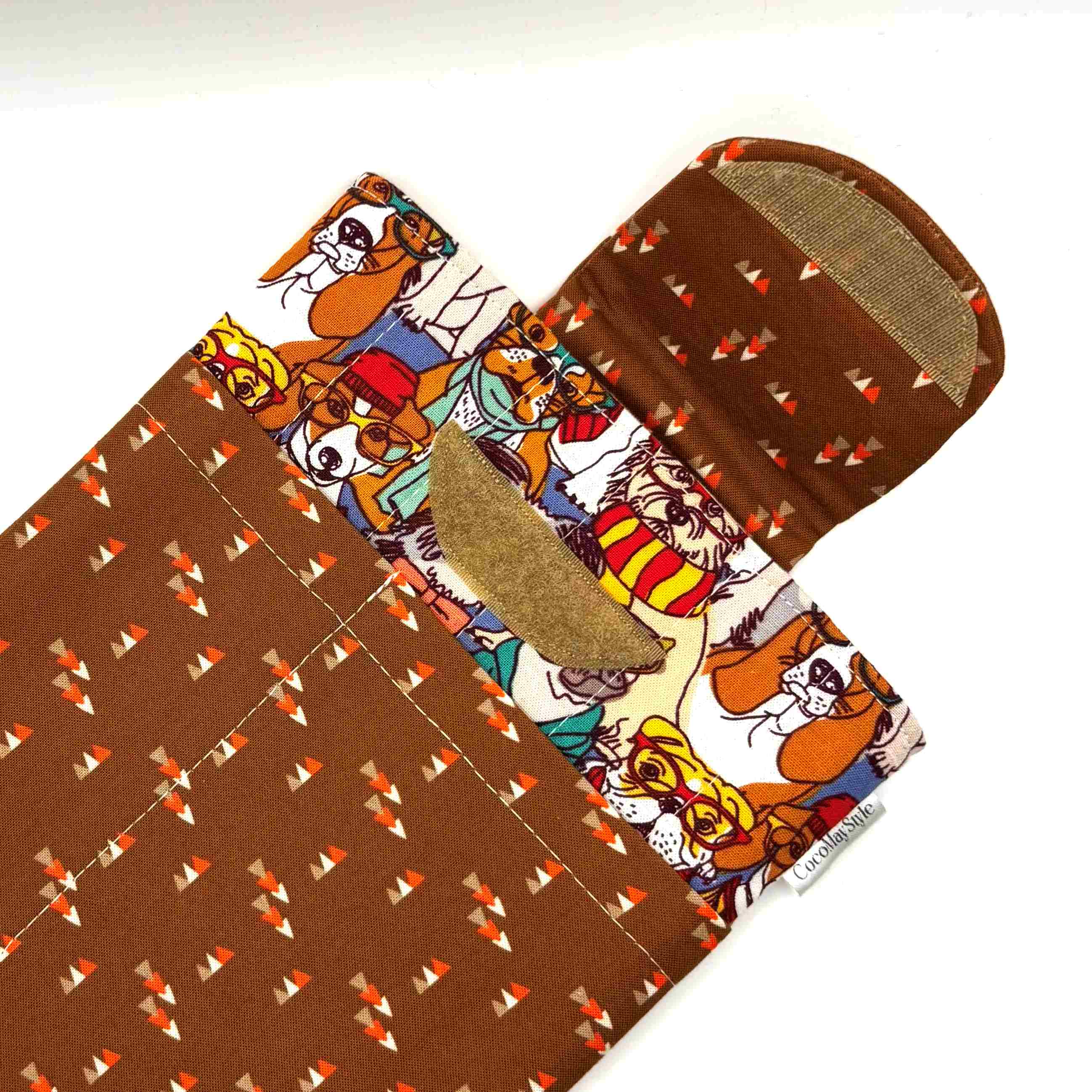 E-Reader sleeve with patterned dogs wearing hats, glasses, and scarves showing open velcro flap