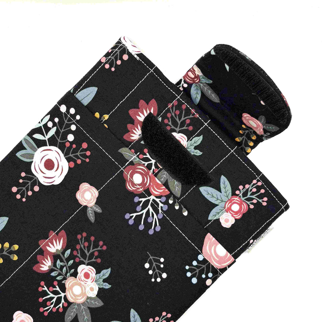 E-Reader sleeve with pink florals on a black background showing open velcro flap