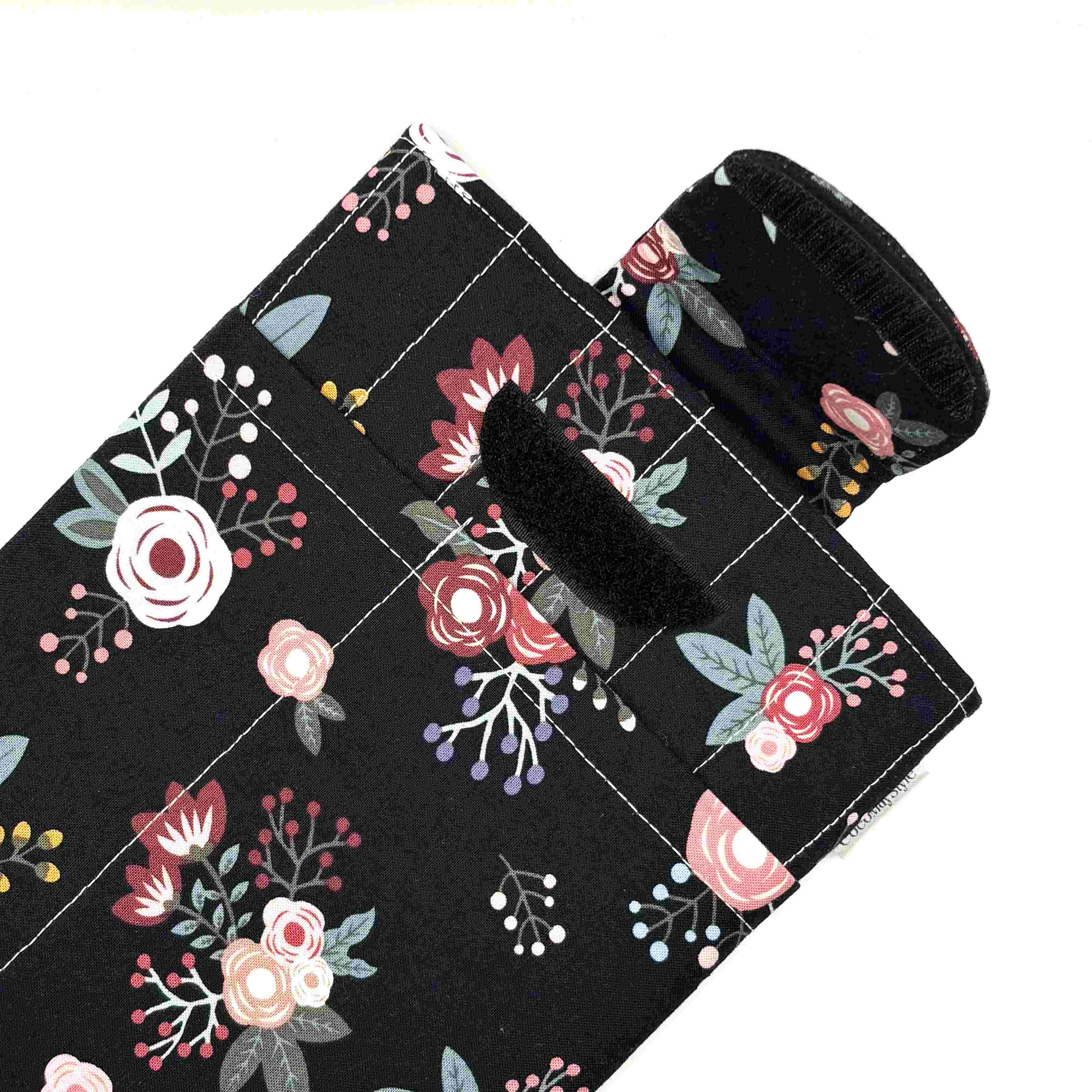 E-Reader sleeve with pink florals on a black background showing open velcro flap