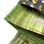 Close-up of e-Reader sleeve with mushroom and foliage design on a black background