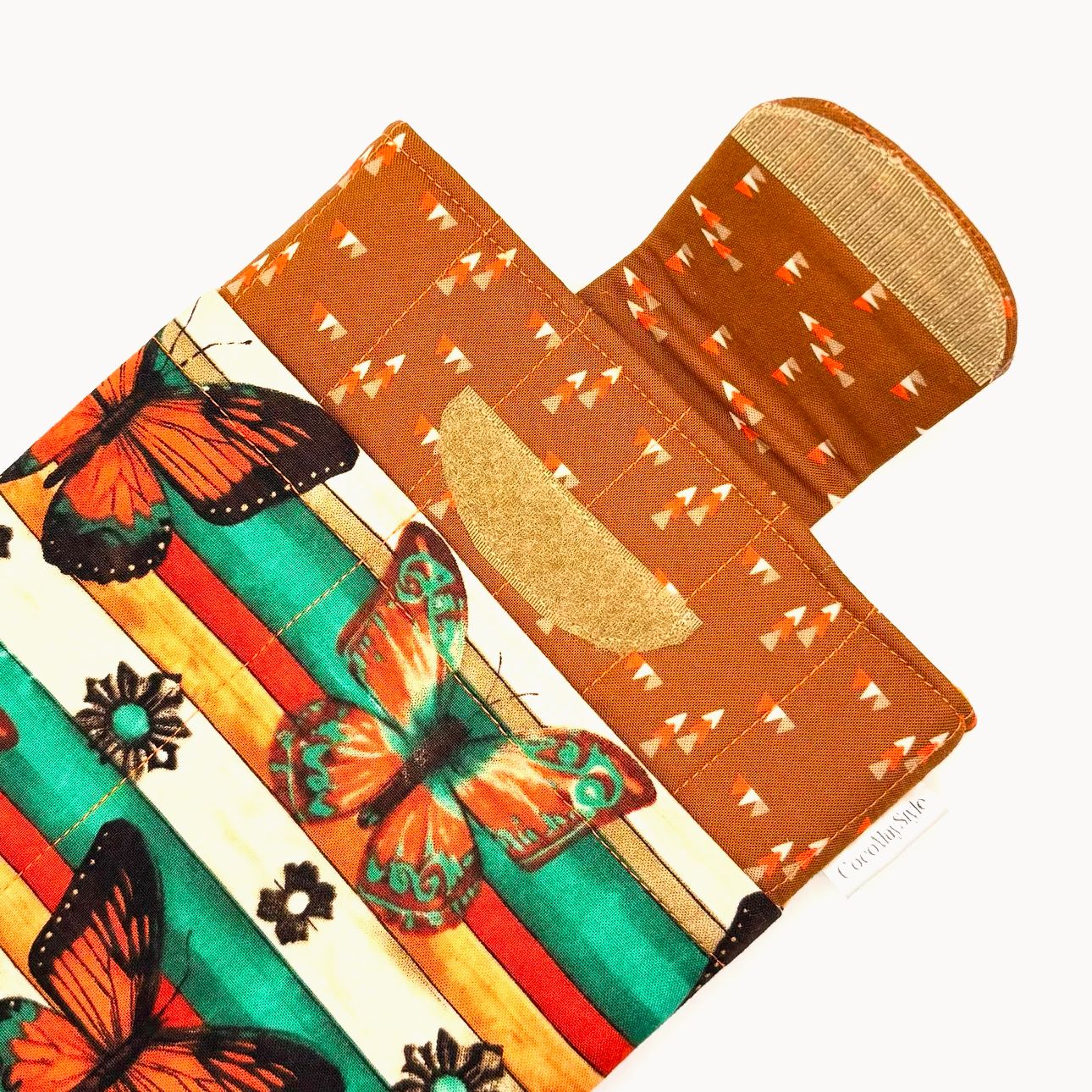 E-Reader sleeve with butterfly design on a striped background showing open velcro flap.