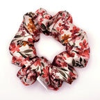 Floral patterned satin scrunchie on a white background