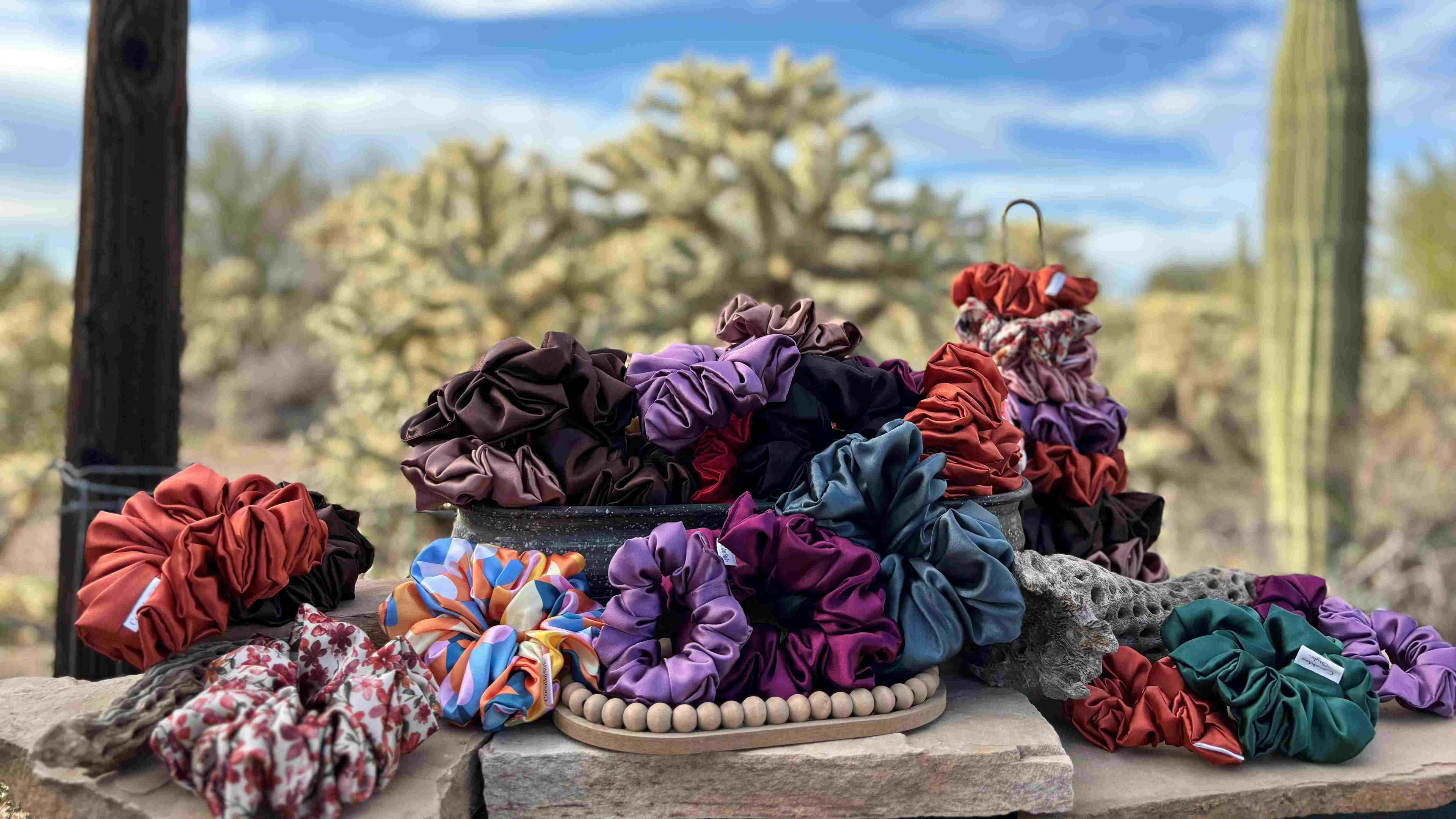 Colorful scrunchies on a wooden stand with desert landscape in the background