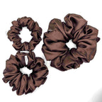 Dark brown satin scrunchies on a white background
