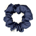 Dark blue satin scrunchie on a white background