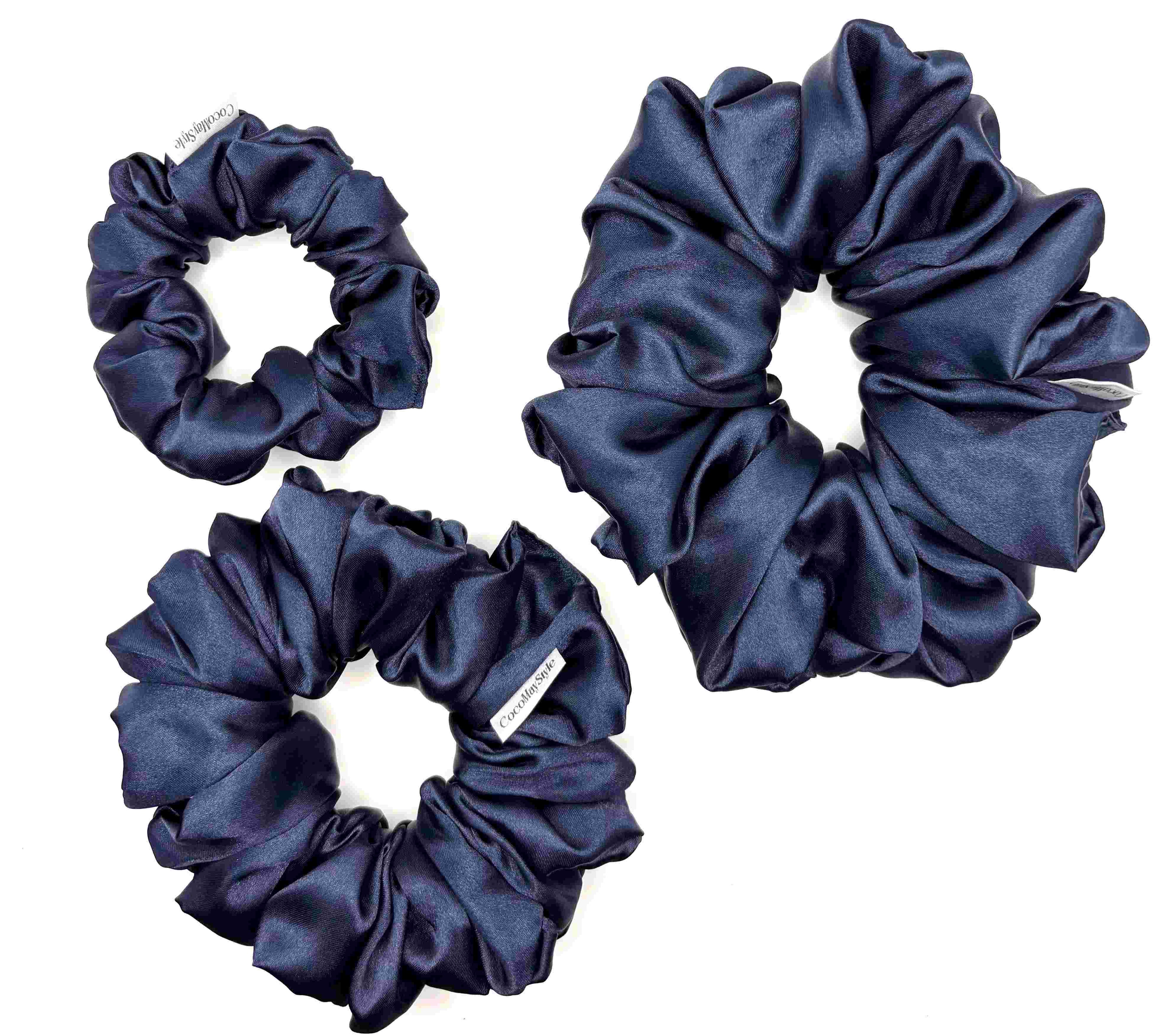Dark blue satin scrunchies on a white background