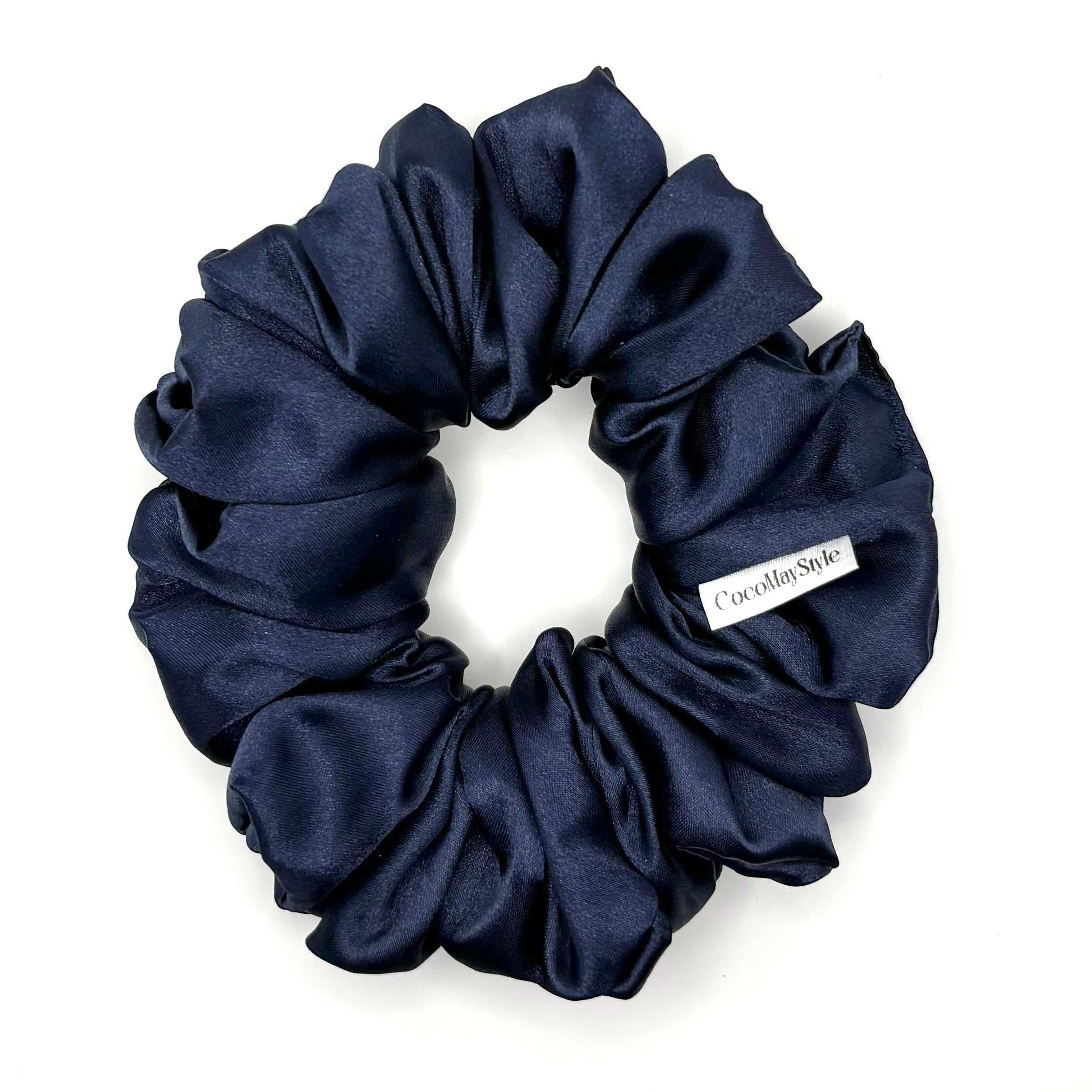 Dark blue satin scrunchie on a white background