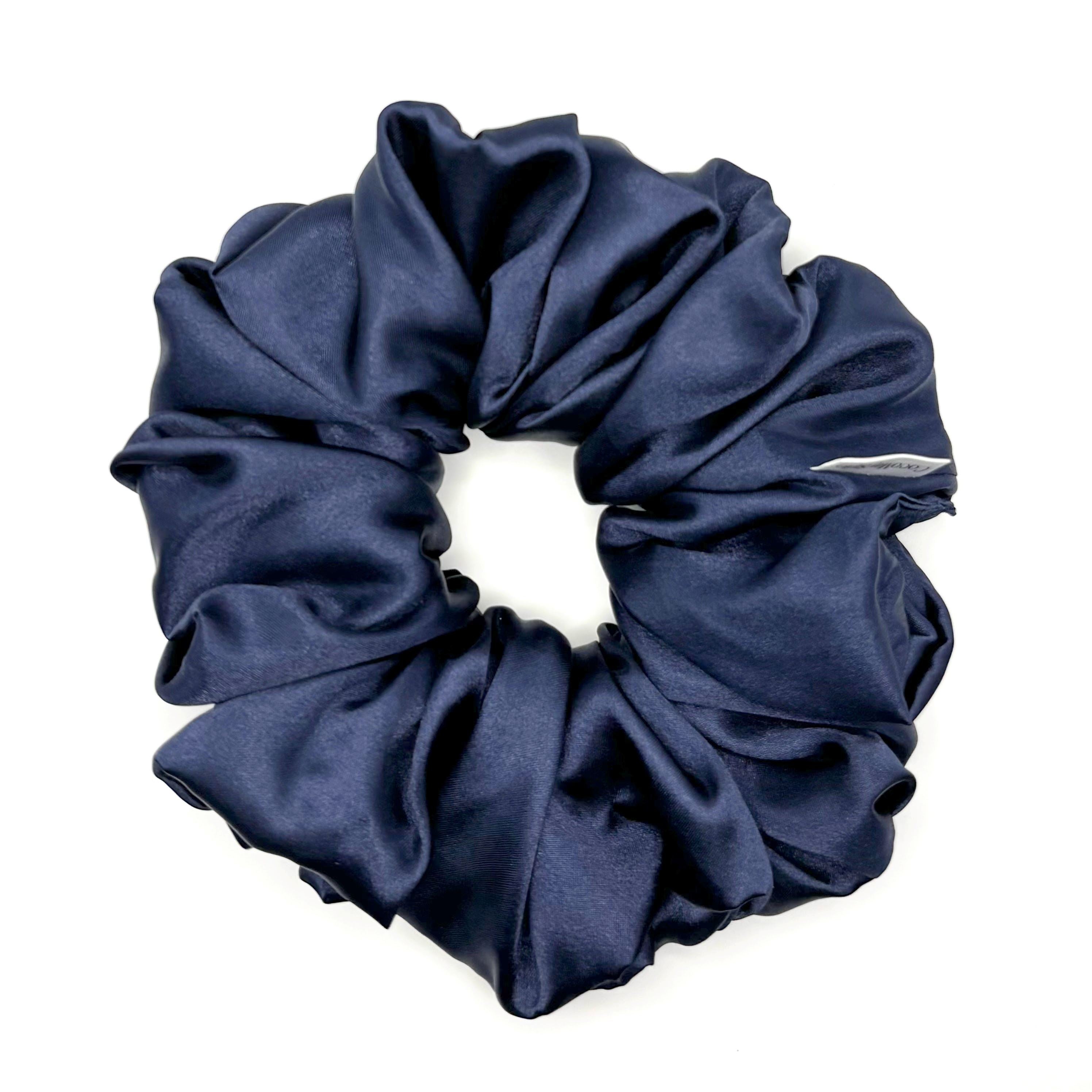 Dark blue satin scrunchie on a white background
