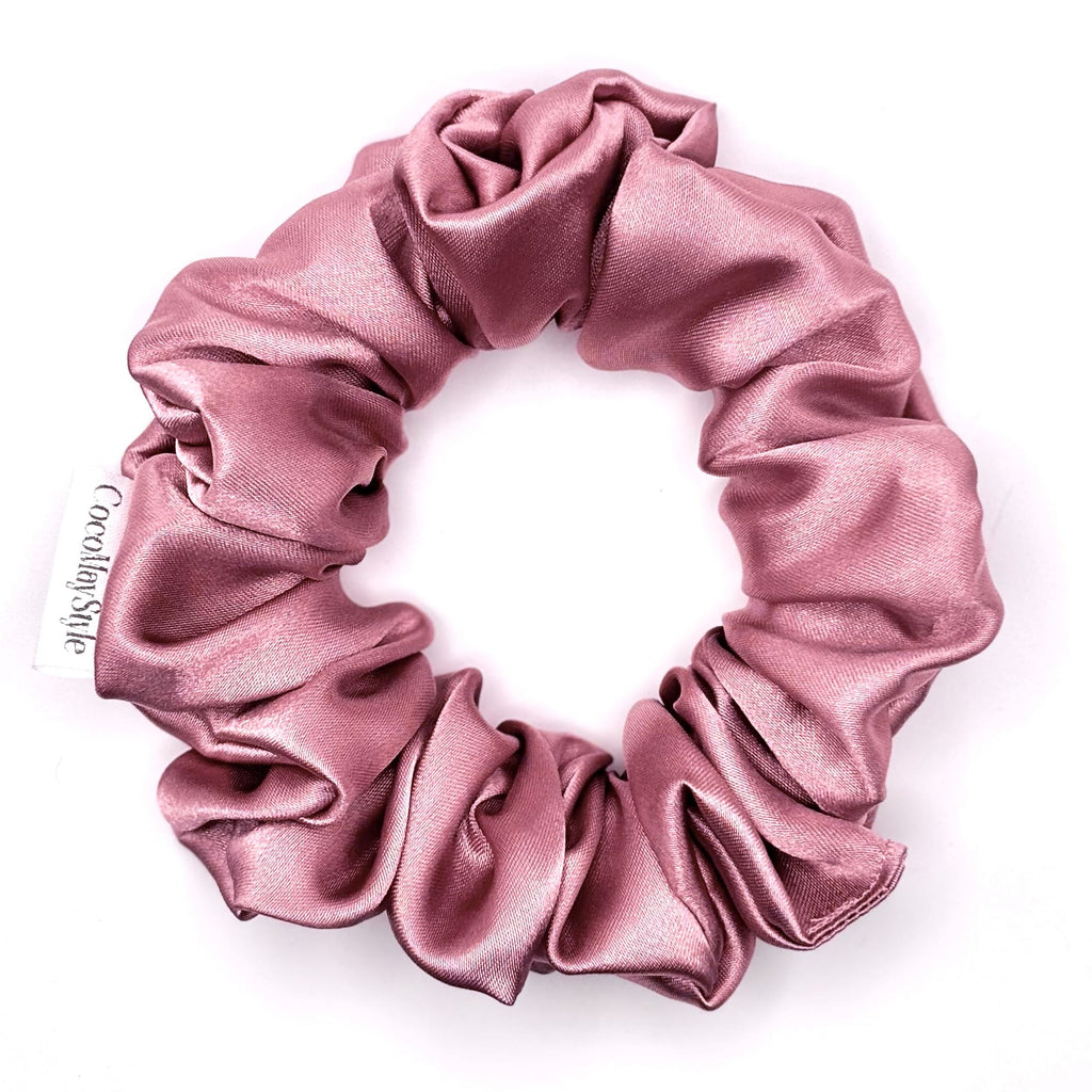 Dusty pink satin scrunchie on a white background