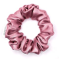 Dusty pink satin scrunchie on a white background