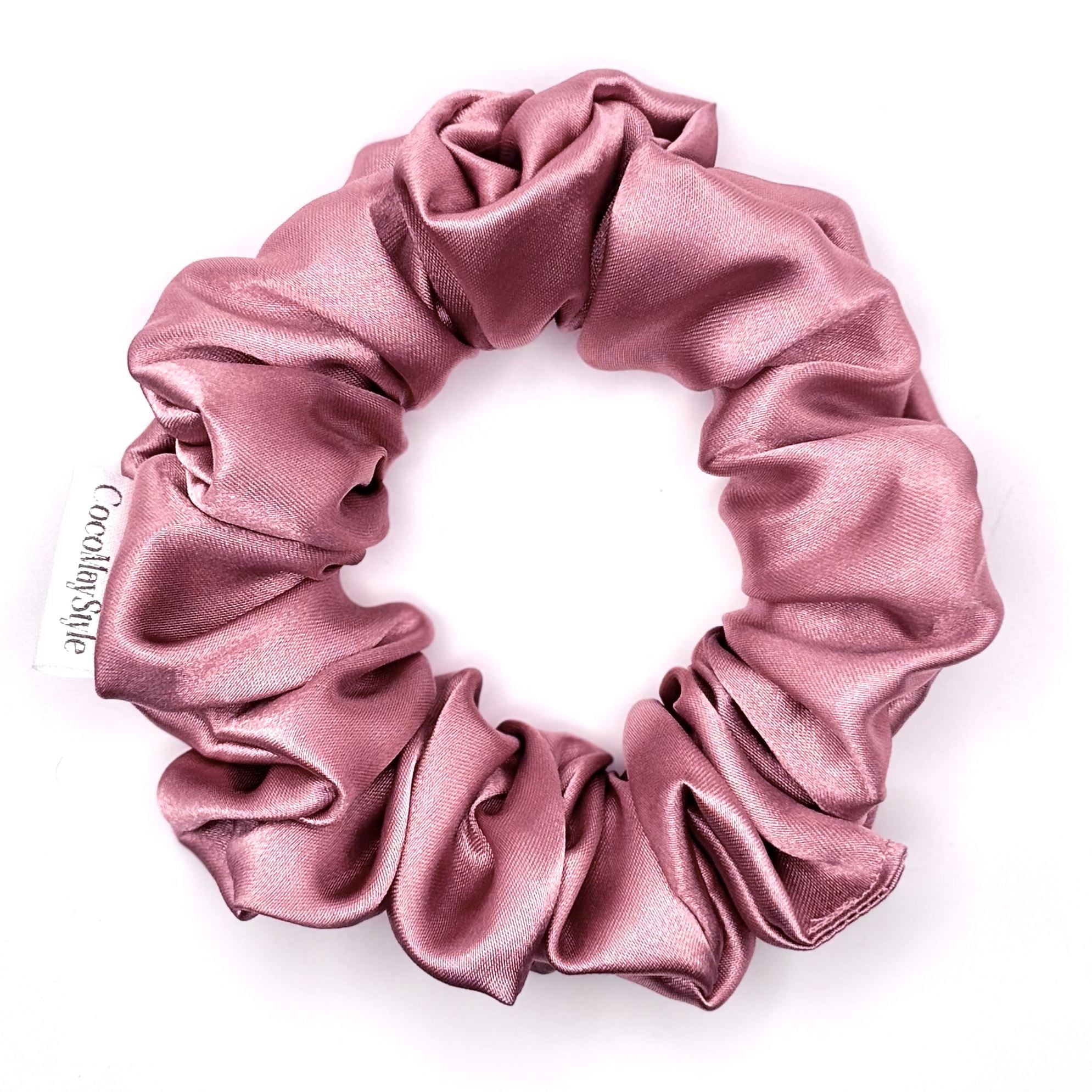Dusty pink satin scrunchie on a white background