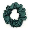 Dark green satin scrunchie on a white background