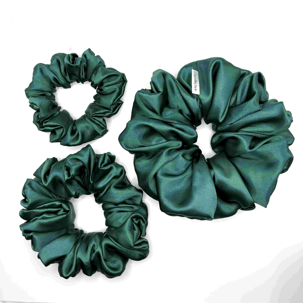 Dark green satin scrunchies on a white background