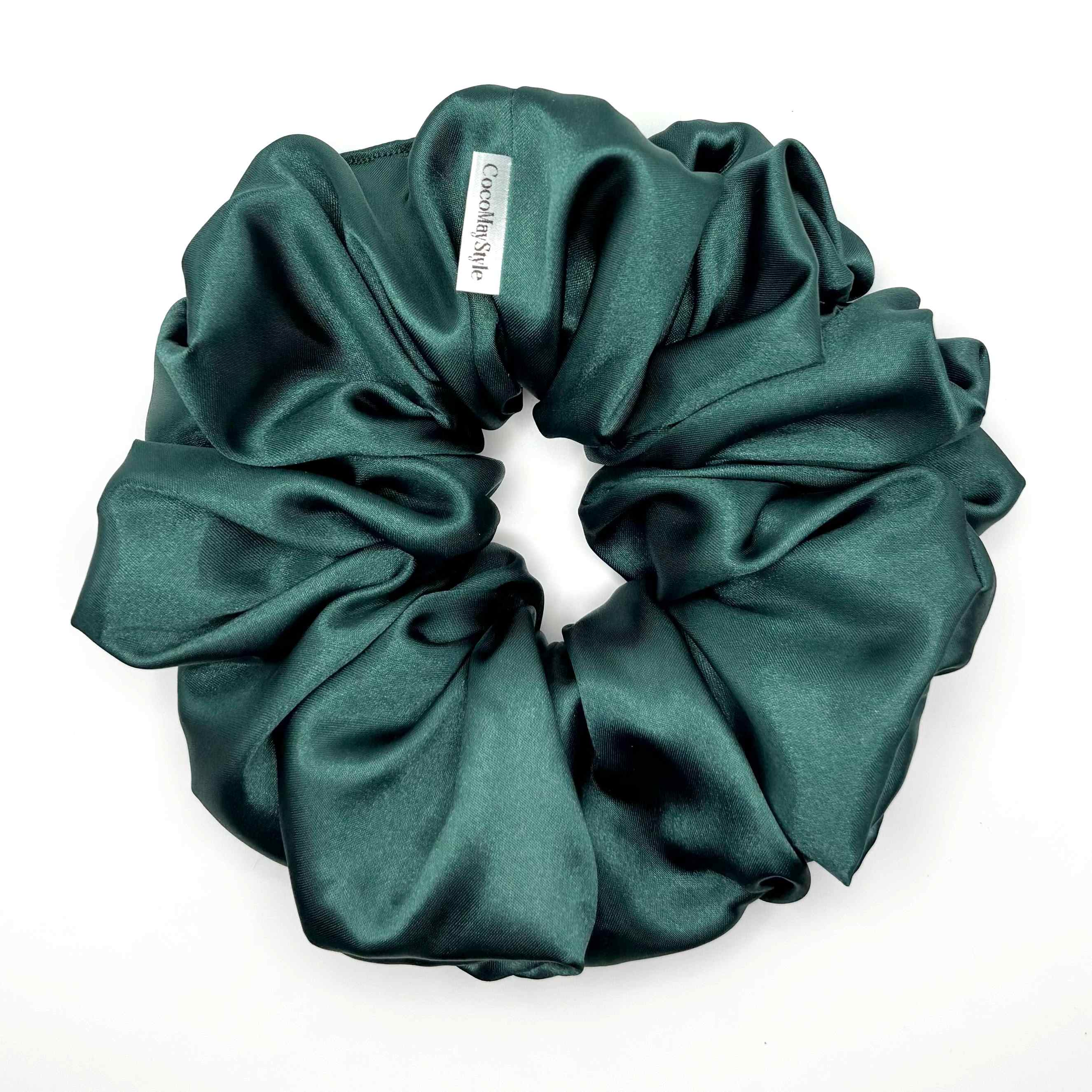 Dark green satin scrunchie on a white background