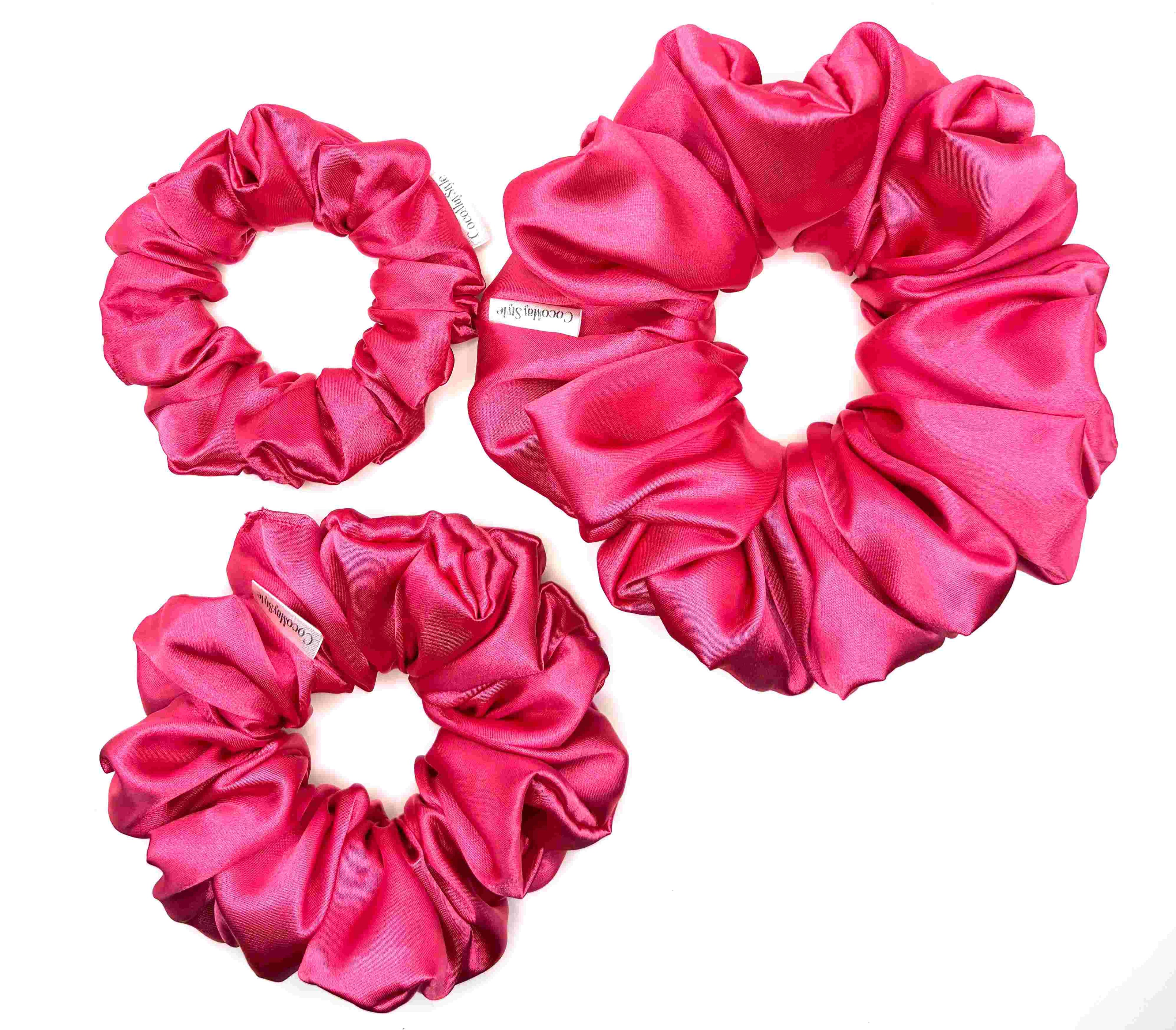 Hot pink satin scrunchies on a white background