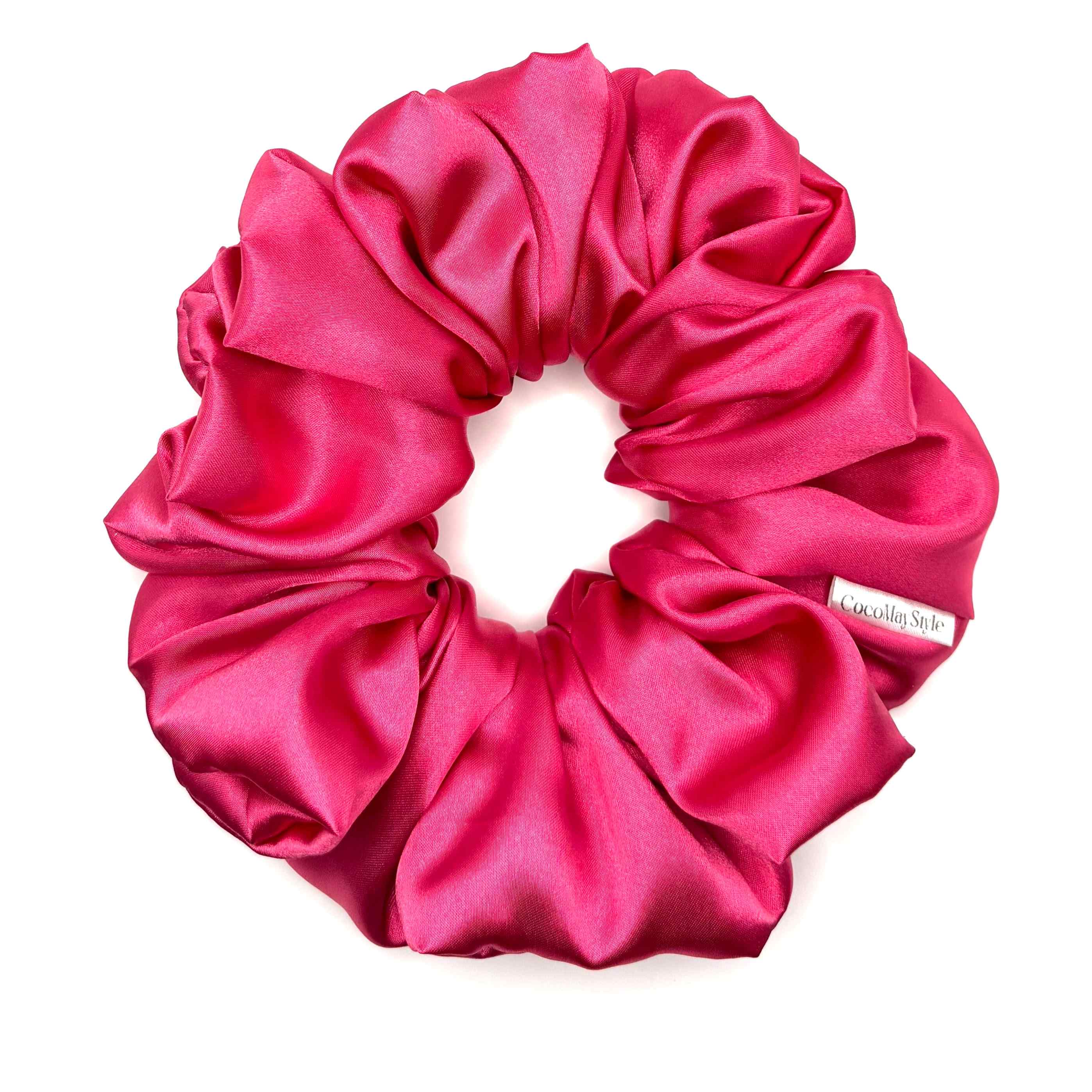 Hot pink satin scrunchie on a white background