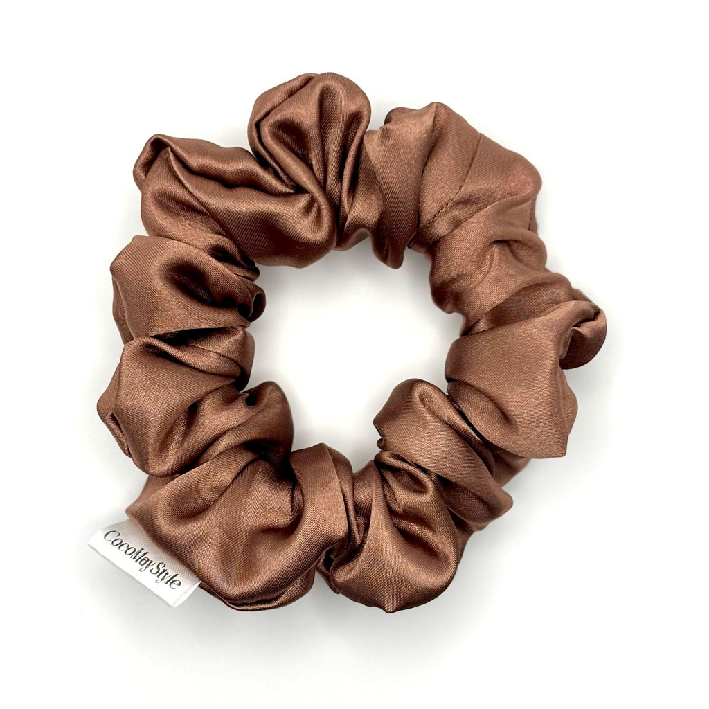 Light brown/tan satin scrunchie on a white background