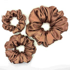 Light brown/tan satin scrunchies on a white background