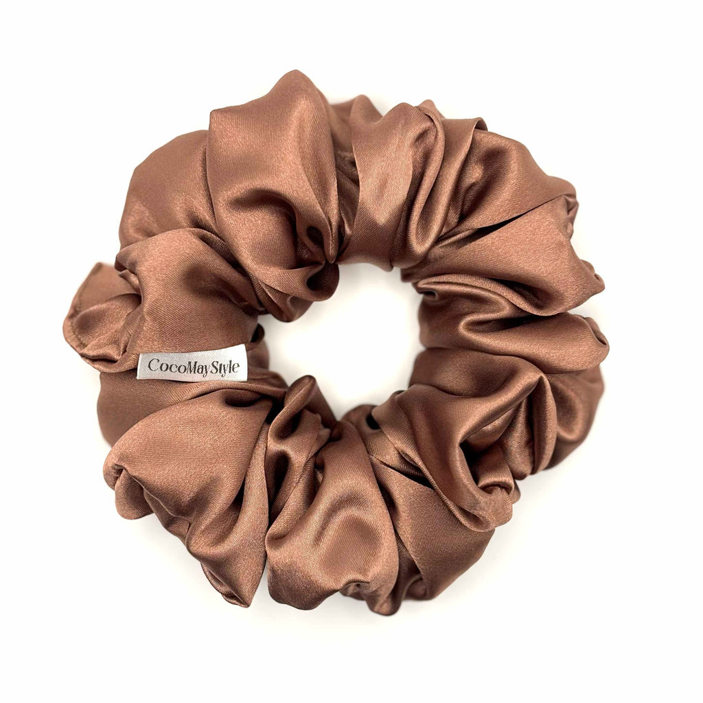 Light brown/tan satin scrunchie on a white background