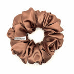 Light brown/tan satin scrunchie on a white background
