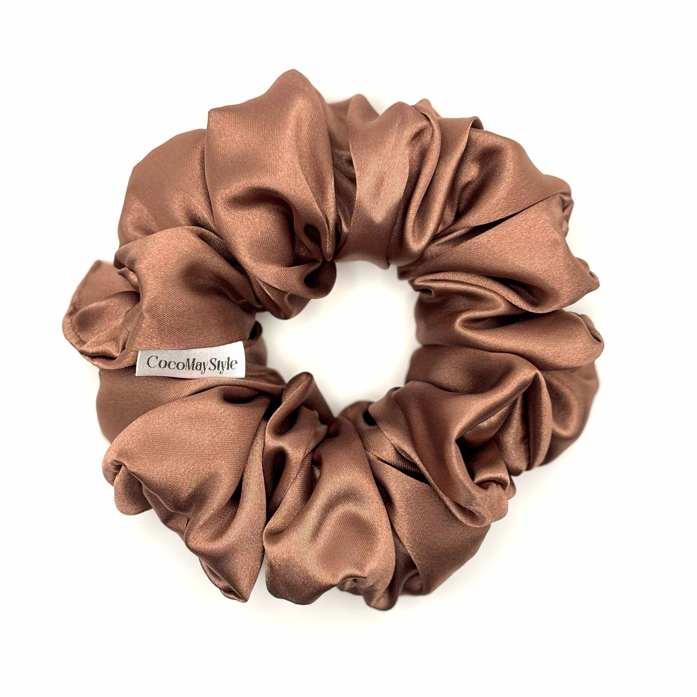 Light brown/tan satin scrunchie on a white background
