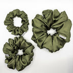 Olive green satin scrunchies on a white background