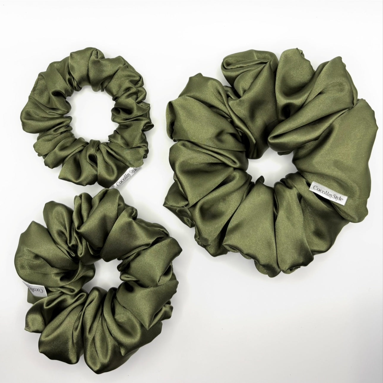 Olive green satin scrunchies on a white background
