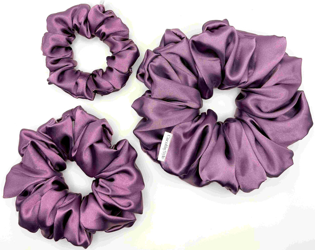 Purple satin scrunchies on a white background