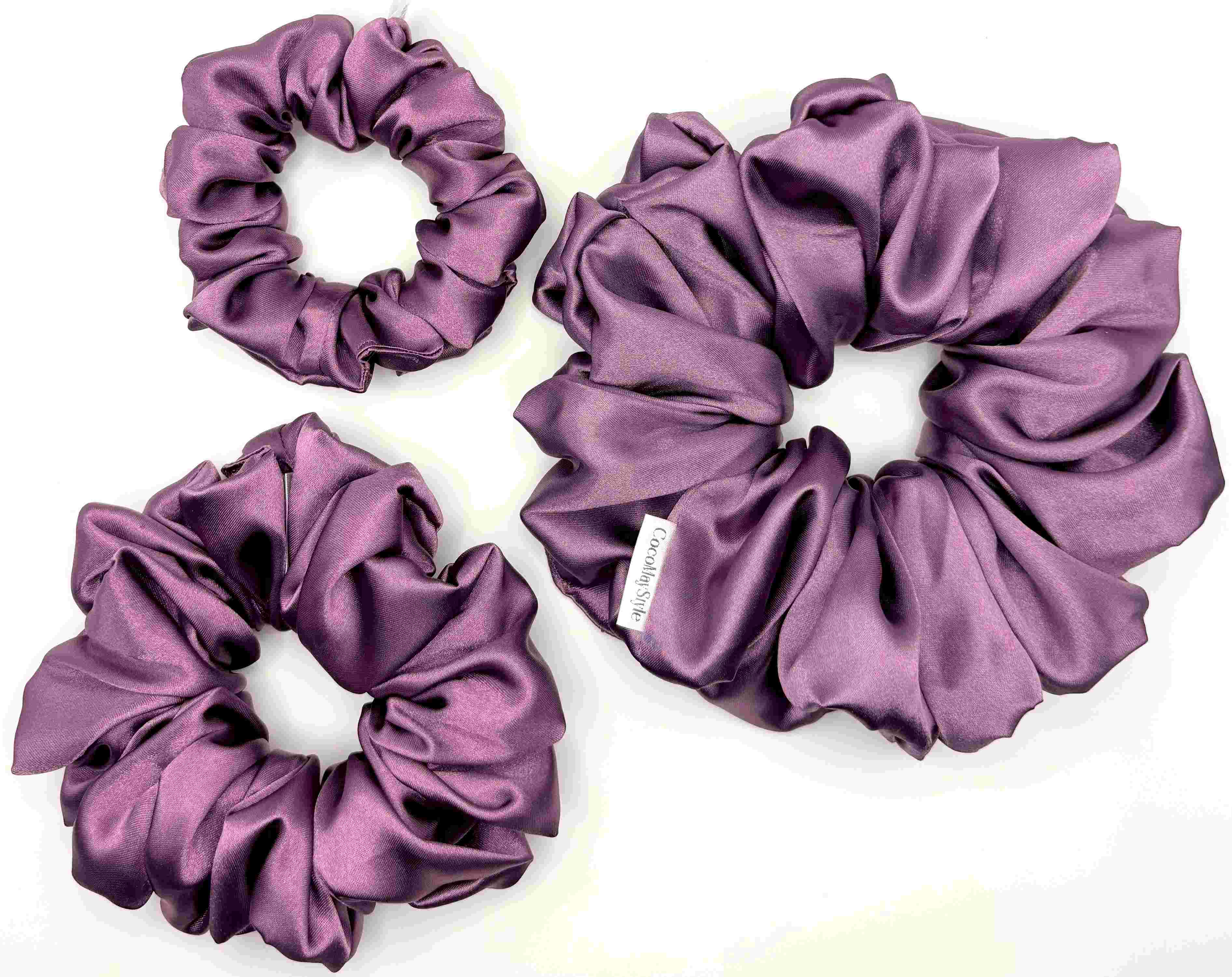 Purple satin scrunchies on a white background