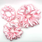 Light pink satin scrunchies on a white background