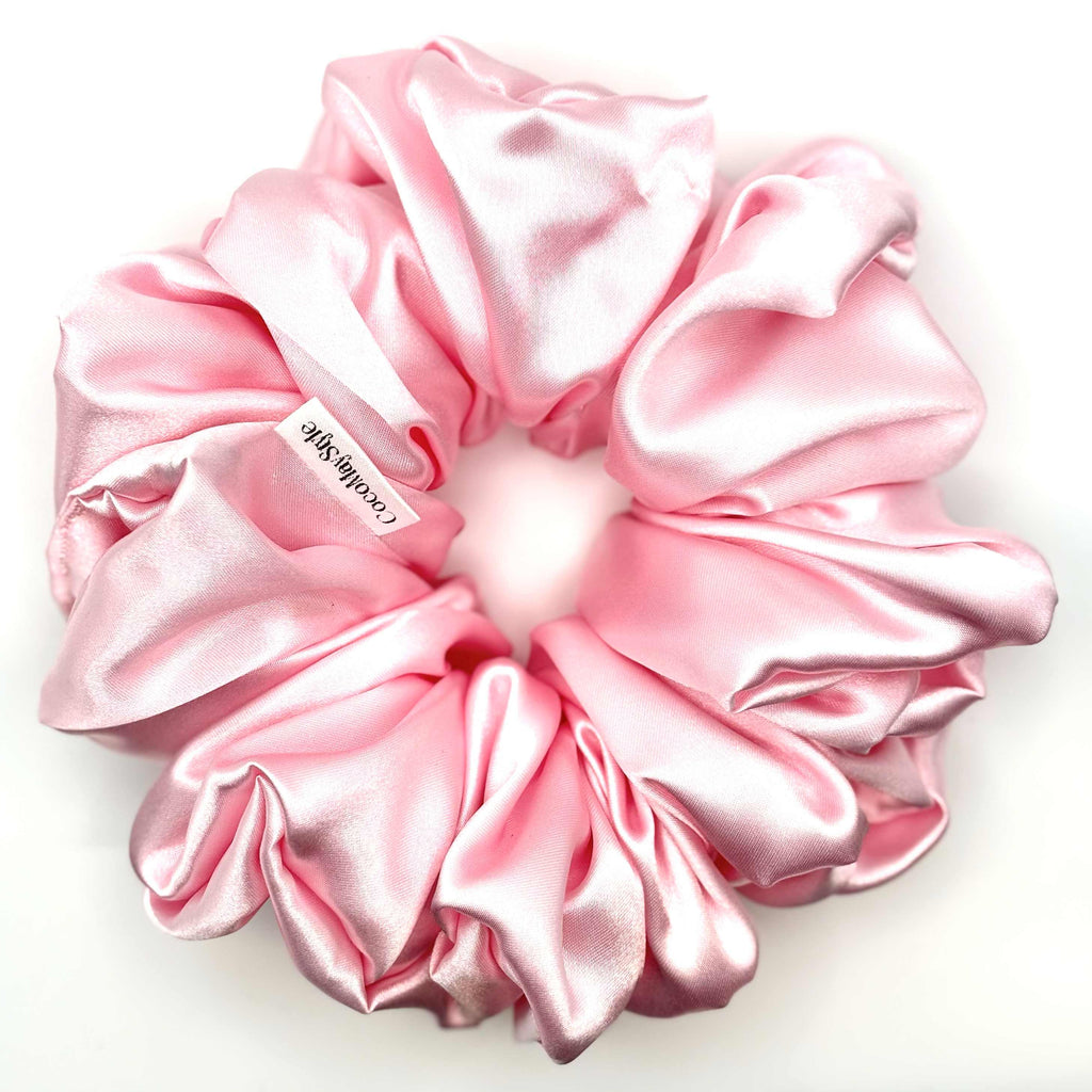 Light pink satin scrunchie on a white background