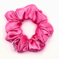 Hot pink satin scrunchie on a white background