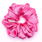 Hot pink satin scrunchie on a white background