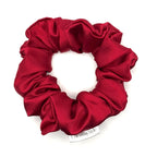 Red satin scrunchie on a white background