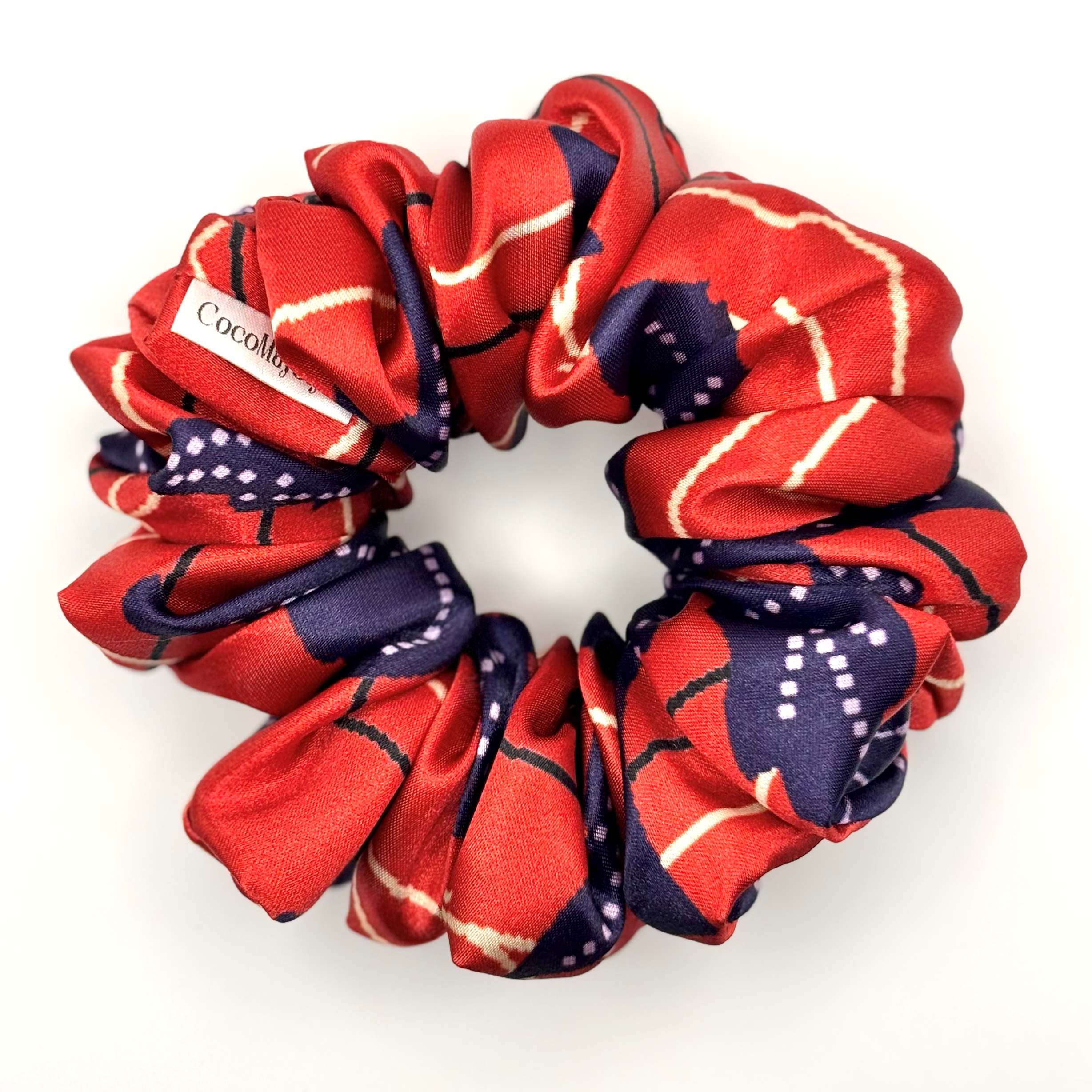 Red and navy patterned satin scrunchie on a white background