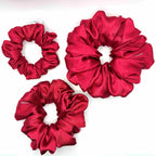 Red satin scrunchies on a white background