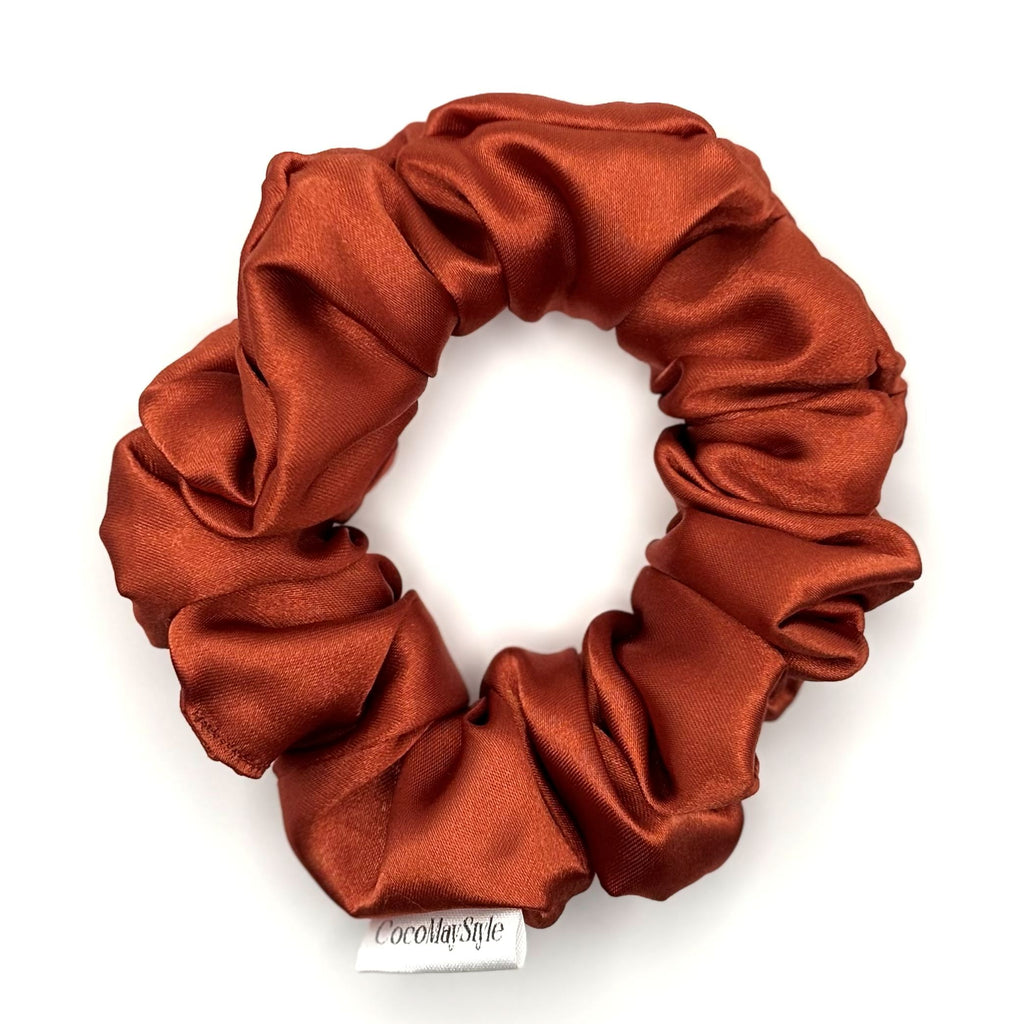 Red orange satin scrunchie on a white background