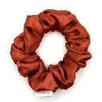 Red orange satin scrunchie on a white background