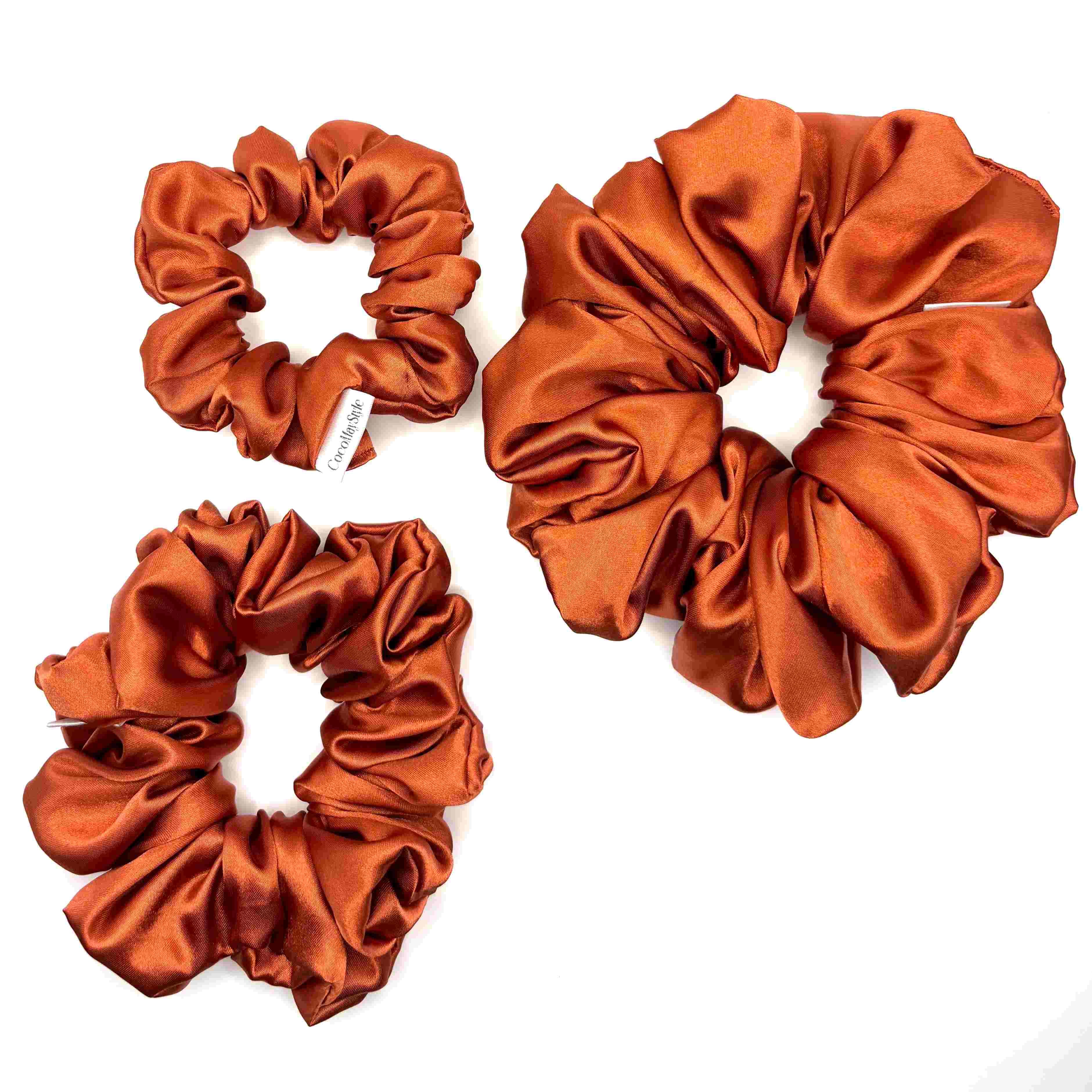 Orange satin scrunchies on a white background