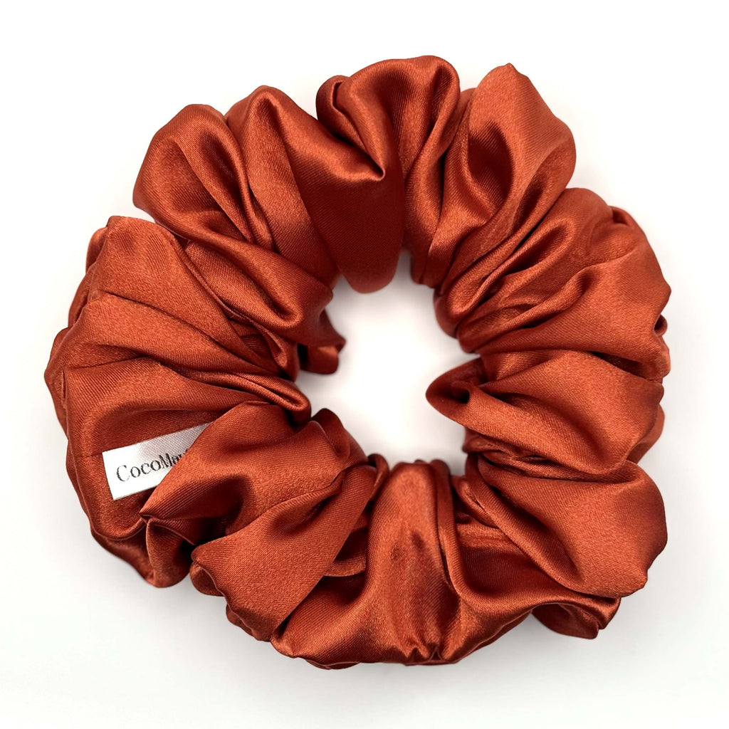 Red orange satin scrunchie on a white background
