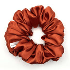 Red orange satin scrunchie on a white background